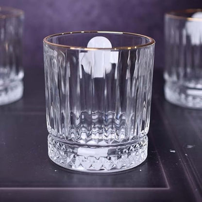 Clear glass with gold rim on a dark surface