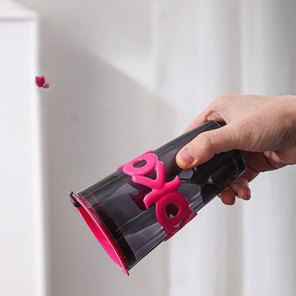 Hand holding a black and pink device with 'LOVE' on it against a light background