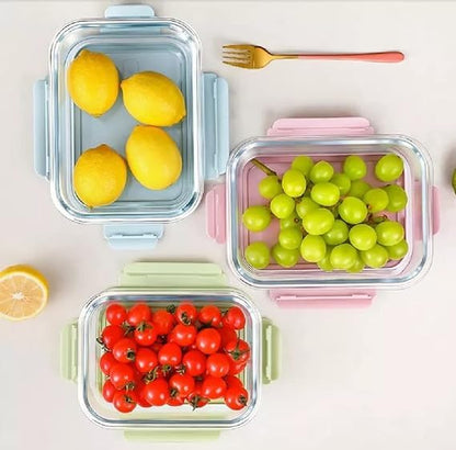 Three food storage containers with lemons, grapes, and cherry tomatoes on a light background.