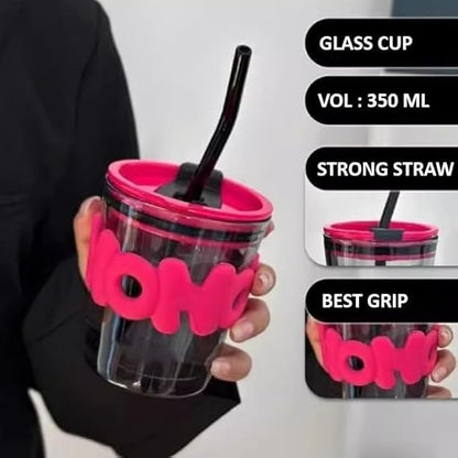 Clear glass cup with pink holder, black straw, and 'boba' branding held by a person.