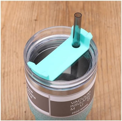 Vacuum insulated mug with a turquoise straw lid on a wooden surface
