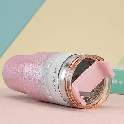 Pink insulated bottle with a clear lid on a colorful background