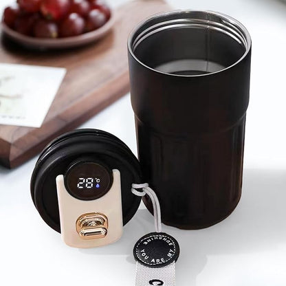 Black insulated travel mug with digital temperature display on a white surface.