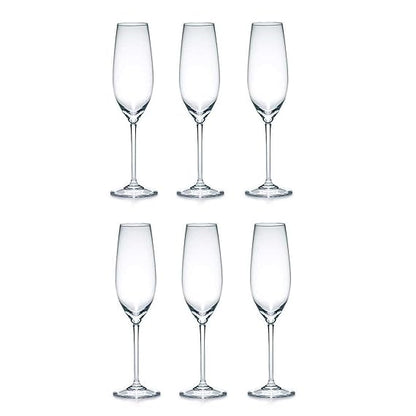 Set of six clear champagne flutes on a white background