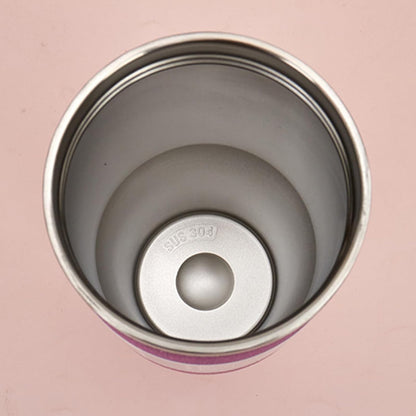 Stainless steel tumbler with a pink band on a pink background