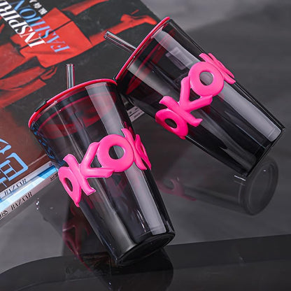 Black tumblers with pink 'okom' branding on a reflective surface.