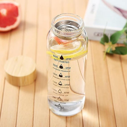 Glass water bottle with time markers on a wooden surface