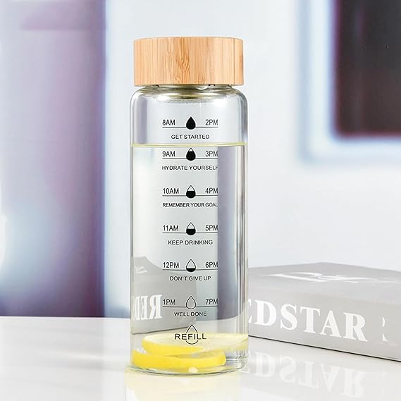 Clear water bottle with bamboo cap and time markers on a blurred background