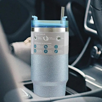 Silver insulated tumbler with a label on a car dashboard