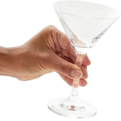 Hand holding a clear martini glass against a white background