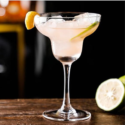 Cocktail in a margarita glass with ice and lime garnish on a wooden surface.