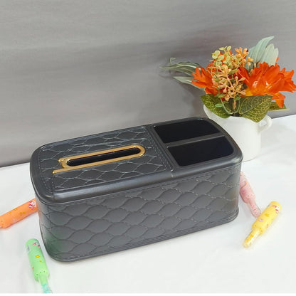 Gray quilted tissue box with a gold handle on a white surface with flowers in the background