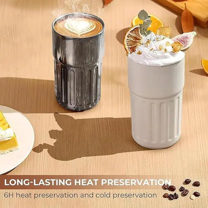 Two insulated cups on a wooden surface with coffee and dessert.