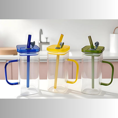 Three colorful cups with handles and straws on a light background