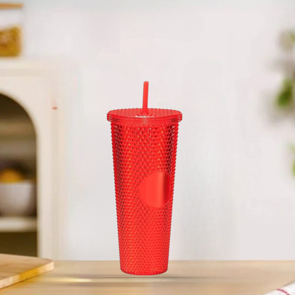 Red textured tumbler with a straw on a light surface
